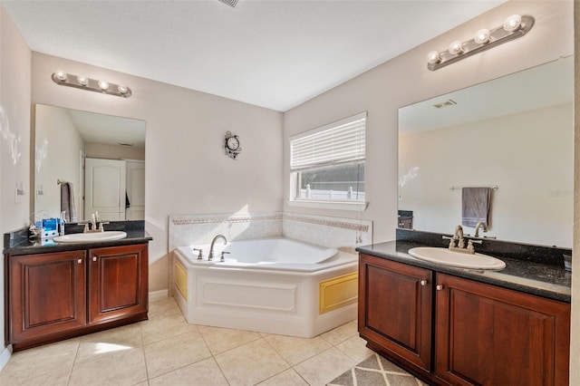 bathroom with tile patterned flooring, a bathtub, and vanity