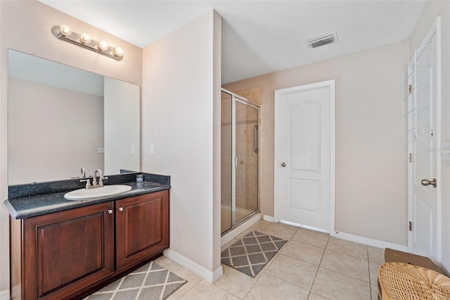 bathroom featuring tile patterned flooring, vanity, and a shower with shower door