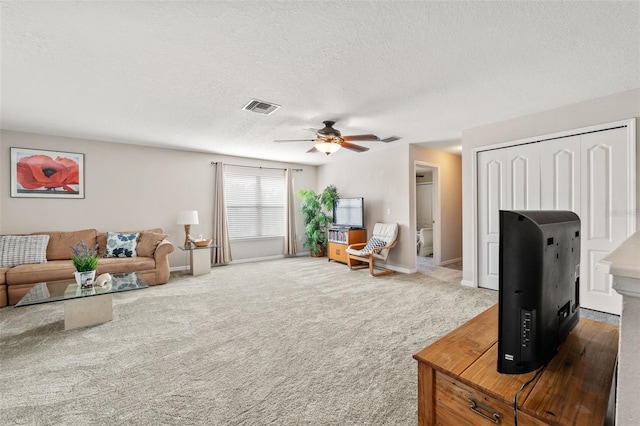 living room featuring a textured ceiling, carpet flooring, and ceiling fan