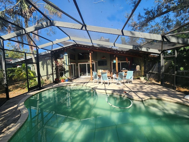 view of swimming pool with a lanai, ceiling fan, and a patio area