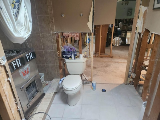 bathroom featuring tile patterned floors, tile walls, and toilet