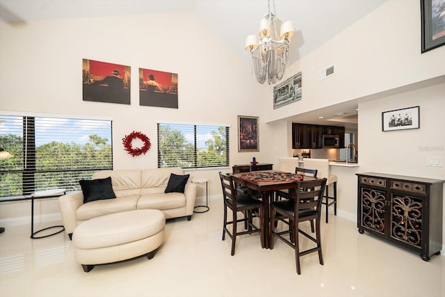 tiled dining area featuring high vaulted ceiling, a notable chandelier, and sink