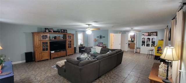 tiled living room with a textured ceiling and ceiling fan