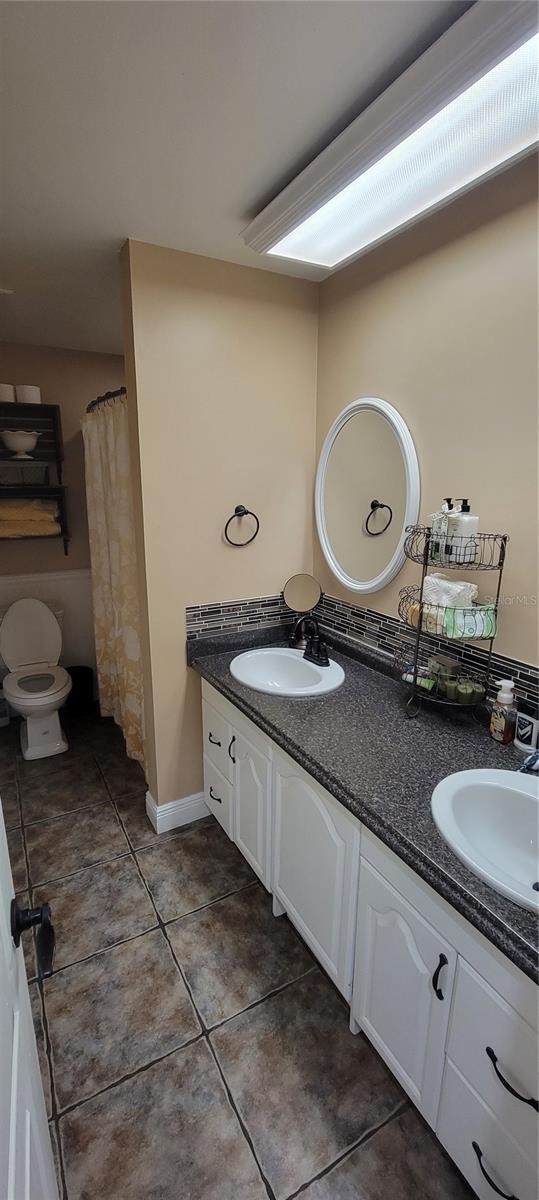 bathroom featuring tile patterned flooring, vanity, and toilet