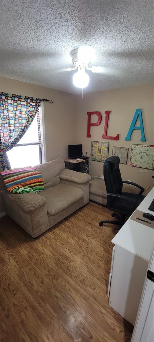 office with ceiling fan, wood-type flooring, and a textured ceiling