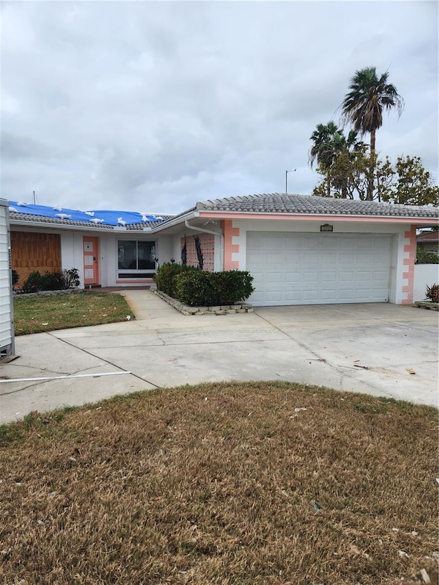 single story home featuring a garage and a front lawn