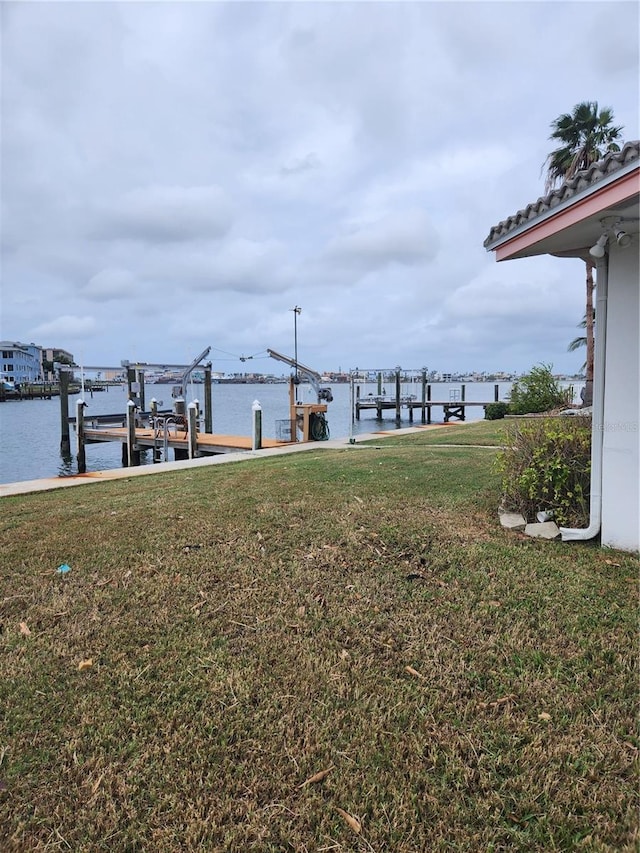 12520 4th St E, Treasure Island, FL 33706 - view of grassy yard with boat lift, a dock, and a water view