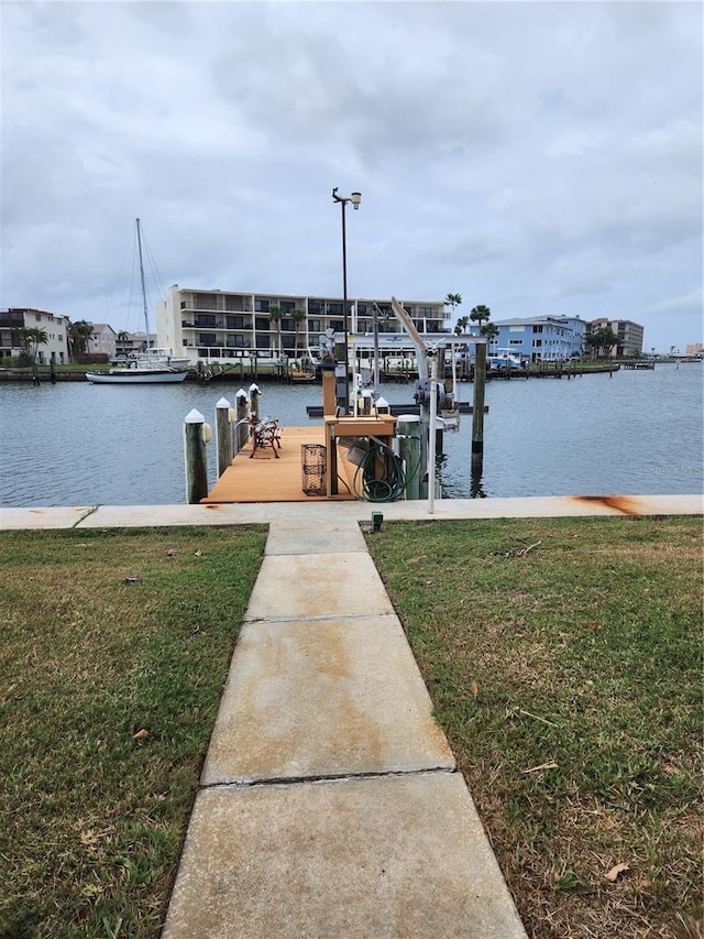 dock area with a water view and a yard