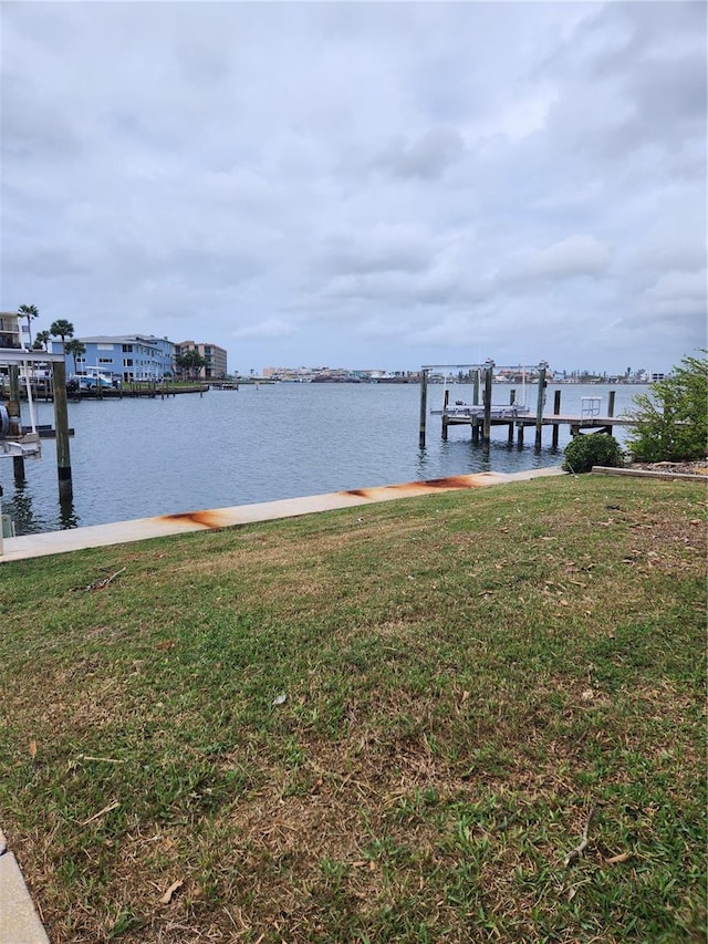 view of dock with a water view and a lawn