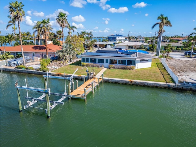 dock area with a lawn and a water view