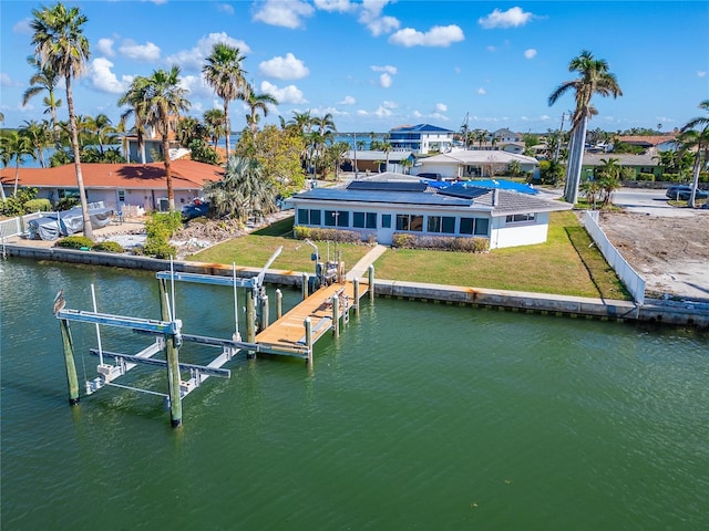 12520 4th St E, Treasure Island, FL 33706 - dock featuring boat lift, a water view, a lawn, and a residential view