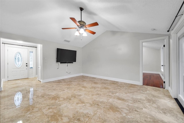 unfurnished living room with lofted ceiling, a textured ceiling, and ceiling fan