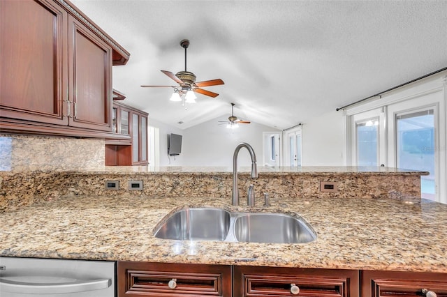 kitchen with backsplash, light stone countertops, sink, vaulted ceiling, and stainless steel dishwasher