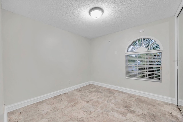 unfurnished room with a textured ceiling