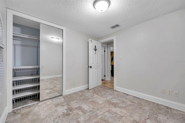 unfurnished bedroom with a closet and a textured ceiling