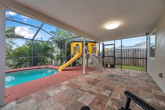 view of swimming pool with glass enclosure and a patio