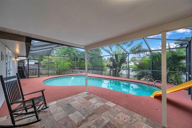 view of pool featuring a lanai, a water view, and a patio area