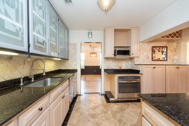 kitchen featuring dark stone countertops, sink, appliances with stainless steel finishes, and decorative backsplash