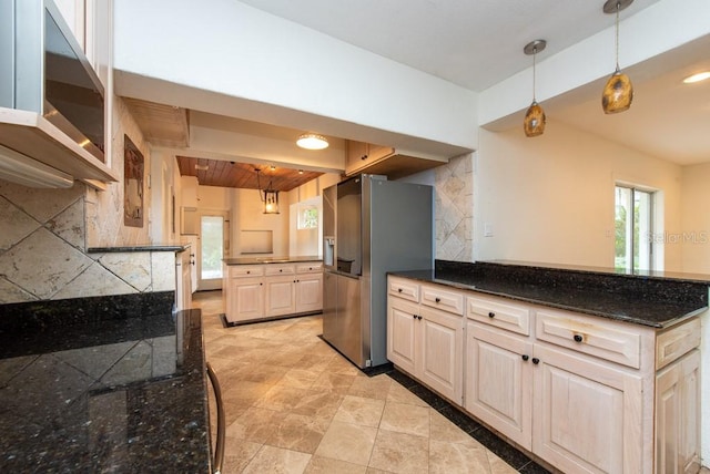 kitchen featuring dark stone counters, backsplash, pendant lighting, and stainless steel appliances