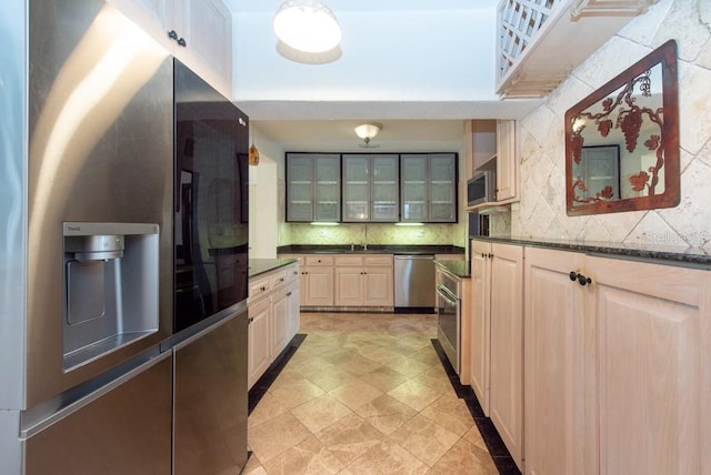 kitchen with light brown cabinets, decorative backsplash, and appliances with stainless steel finishes