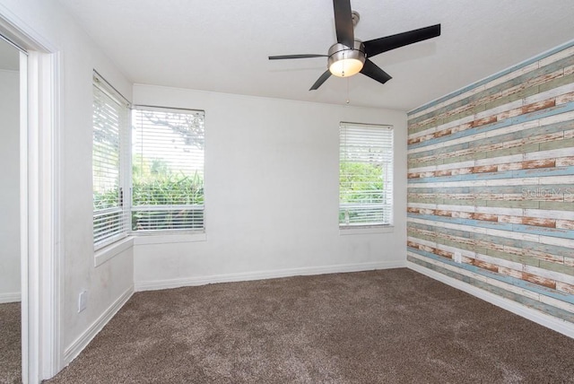 empty room featuring dark colored carpet and ceiling fan