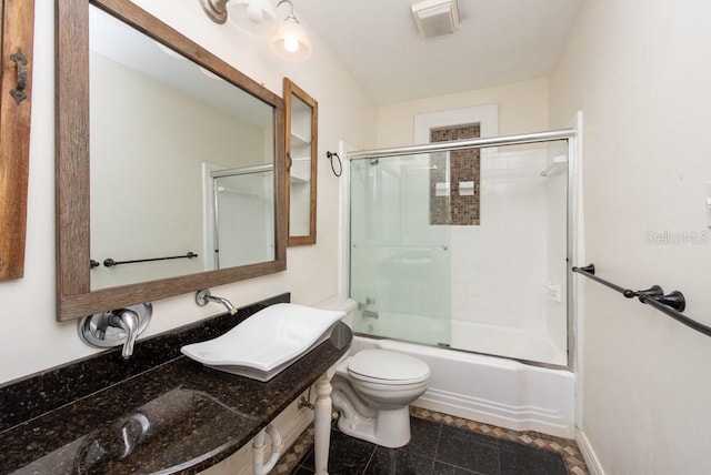 full bathroom featuring tile patterned floors, shower / bath combination with glass door, sink, and toilet