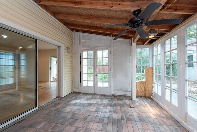 unfurnished sunroom featuring a wealth of natural light, ceiling fan, vaulted ceiling with beams, and french doors