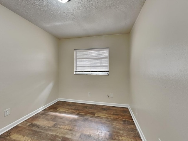 unfurnished room featuring a textured ceiling and dark hardwood / wood-style floors