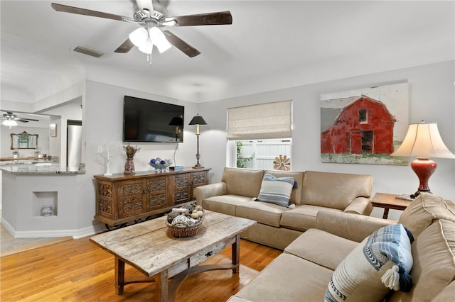 living room featuring ceiling fan and light wood-type flooring