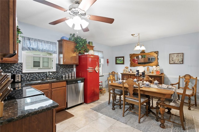 kitchen featuring sink, hanging light fixtures, light tile patterned floors, dishwasher, and decorative backsplash