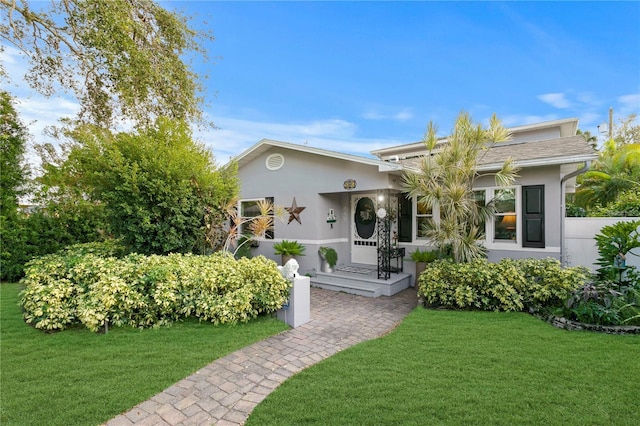 view of front facade with a front yard and stucco siding