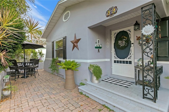 view of exterior entry featuring stucco siding