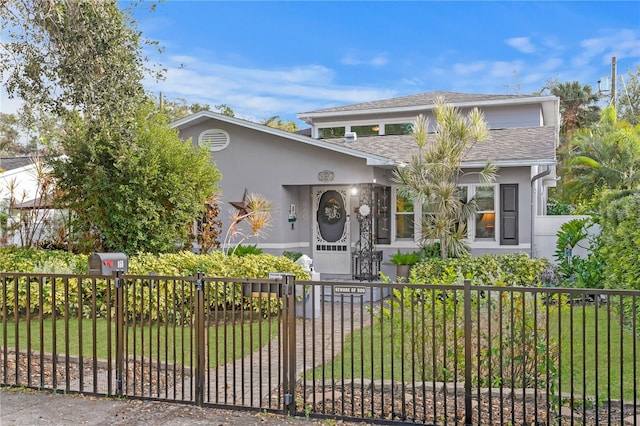 view of front of home featuring a fenced front yard, a front yard, and stucco siding