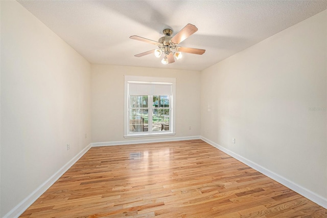 unfurnished room with ceiling fan, a textured ceiling, and light wood-type flooring