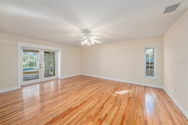 spare room with ceiling fan, french doors, and light wood-type flooring