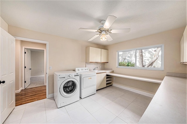 laundry area with ceiling fan, cabinets, a textured ceiling, light tile patterned floors, and washer and dryer