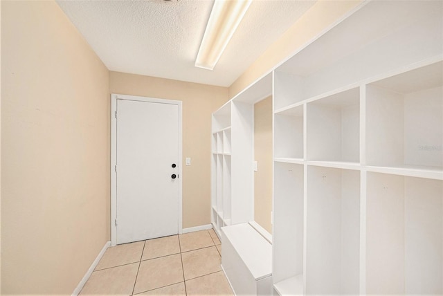 mudroom featuring light tile patterned floors and a textured ceiling