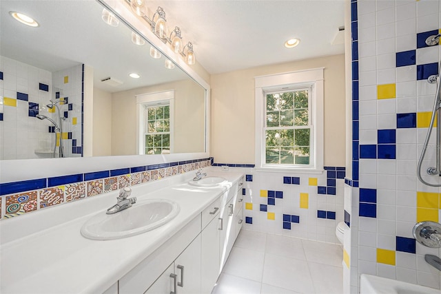 bathroom with tile patterned floors, toilet, a wealth of natural light, and tile walls