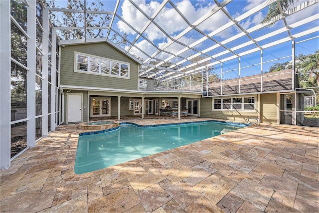 view of pool with a lanai, an in ground hot tub, french doors, and a patio