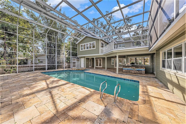 view of swimming pool with glass enclosure and a patio