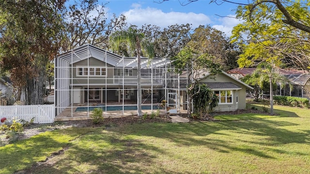 back of house with a lanai and a lawn