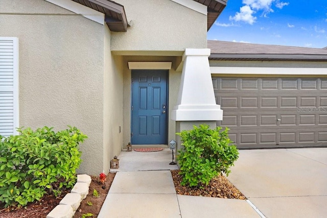 9407 Channing Hill Dr, Ruskin, FL 33573 - entrance to property featuring stucco siding, an attached garage, roof with shingles, and concrete driveway