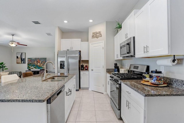 9407 Channing Hill Dr, Ruskin, FL 33573 - kitchen featuring a ceiling fan, appliances with stainless steel finishes, dark stone countertops, and a sink