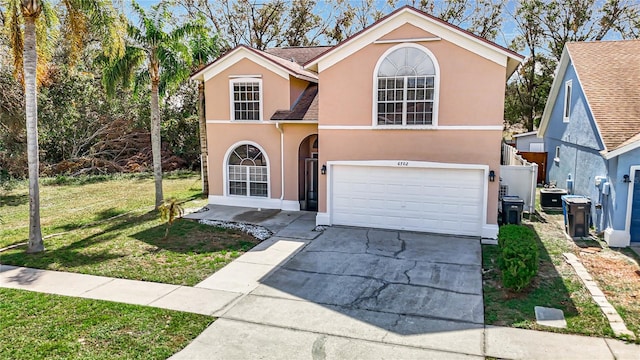 view of property featuring a garage and a front lawn