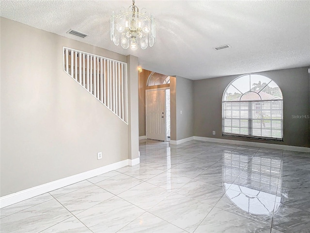 interior space featuring a textured ceiling and an inviting chandelier