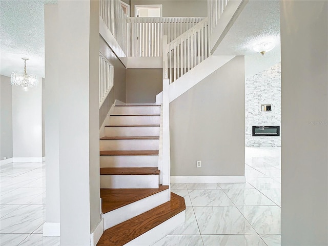 stairs with a towering ceiling and a textured ceiling