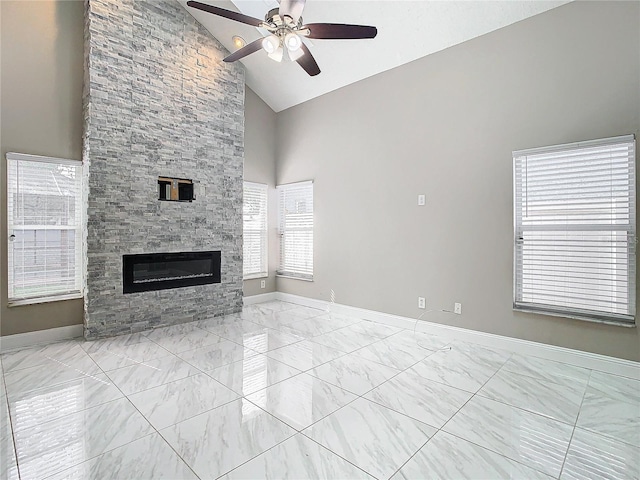 unfurnished living room featuring high vaulted ceiling, a stone fireplace, and ceiling fan