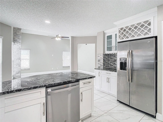 kitchen with white cabinets, a textured ceiling, and stainless steel appliances