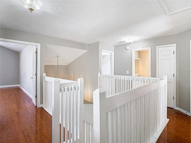 hall with dark hardwood / wood-style flooring and a textured ceiling