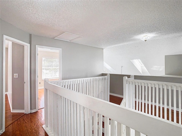 corridor with hardwood / wood-style flooring and a textured ceiling